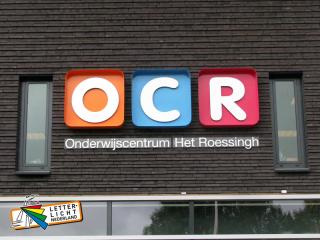 Gefreesde letters op afstand in doos op kleur gespoten onderwijscentrum